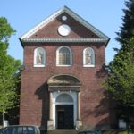 Die Figuren an der Fassade (hl. Petrus links und hl. Andreas rechts) erinnern an den ursprünglichen Titel der Kirche: "St. Petrus und Andreas".